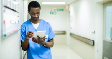 Male nurse looking at tablet in hospital - Video Platforms HealthStream